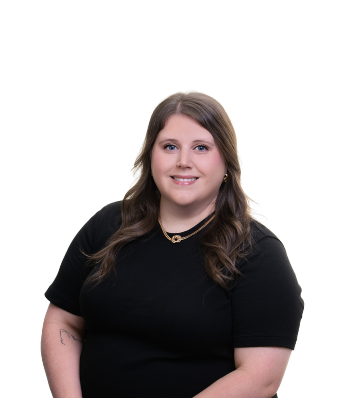 Meet Our Team - Professional and Welcoming Group at a Conference Table Faces the Camera, Team Leader Sitting on the Table with Arms Folded